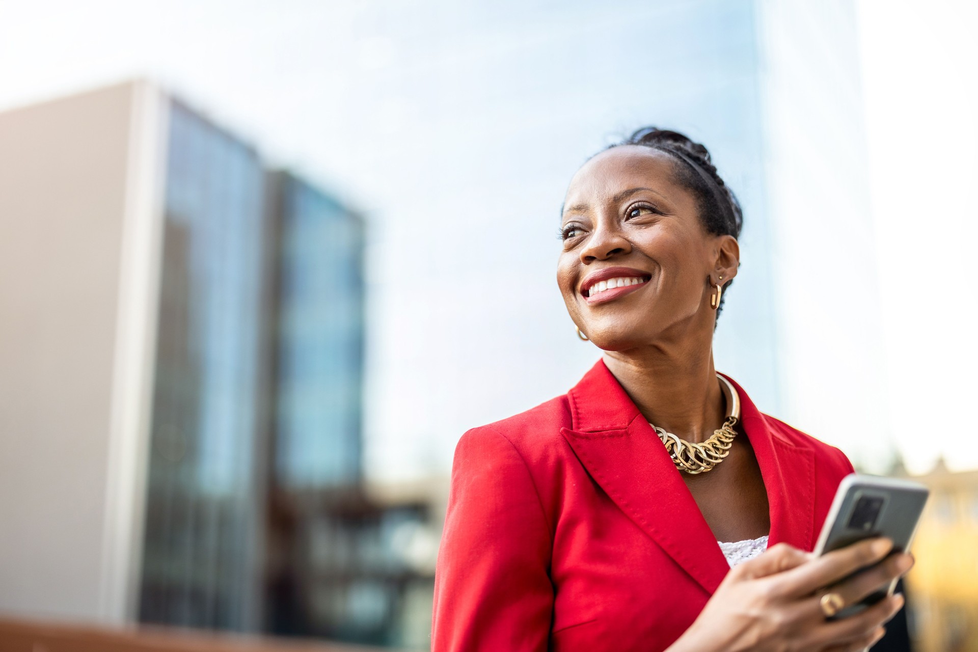 Portrait of smiling mature businesswoman using mobile phone in urban setting